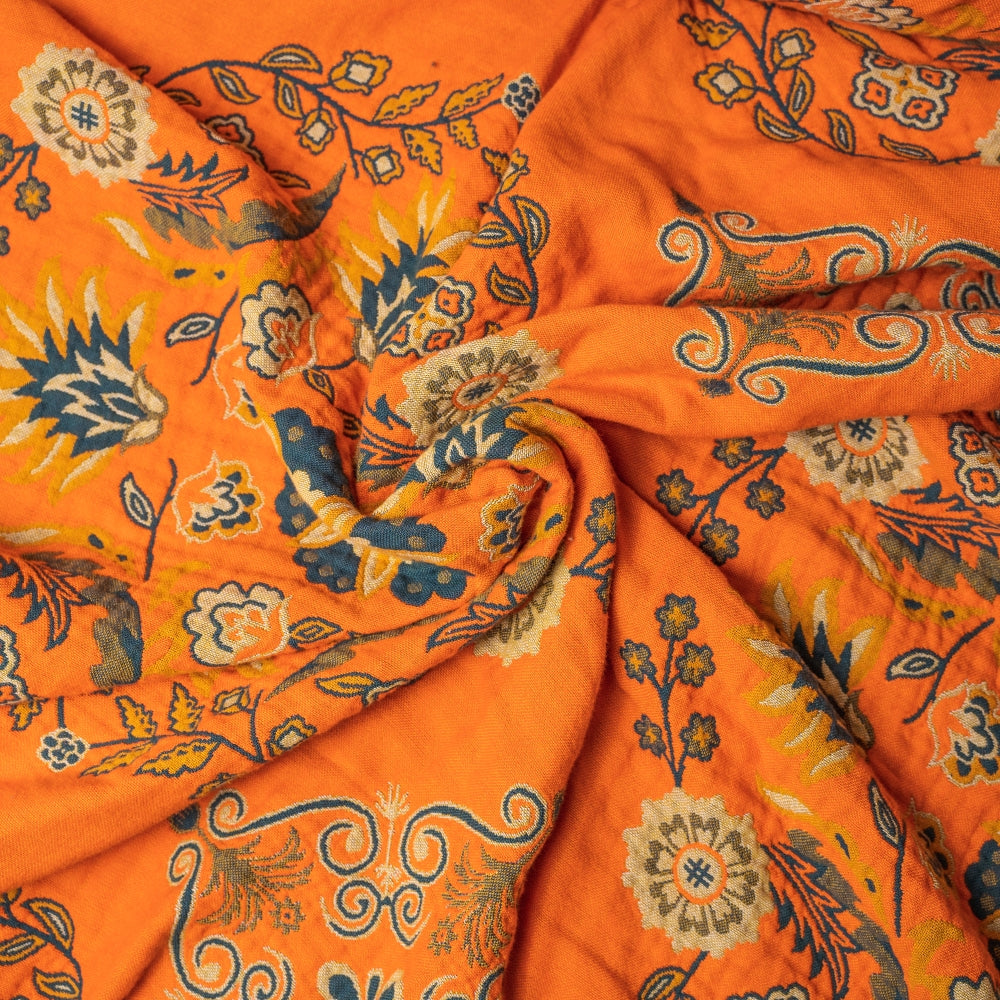 Orange fabric with floral and paisley patterns