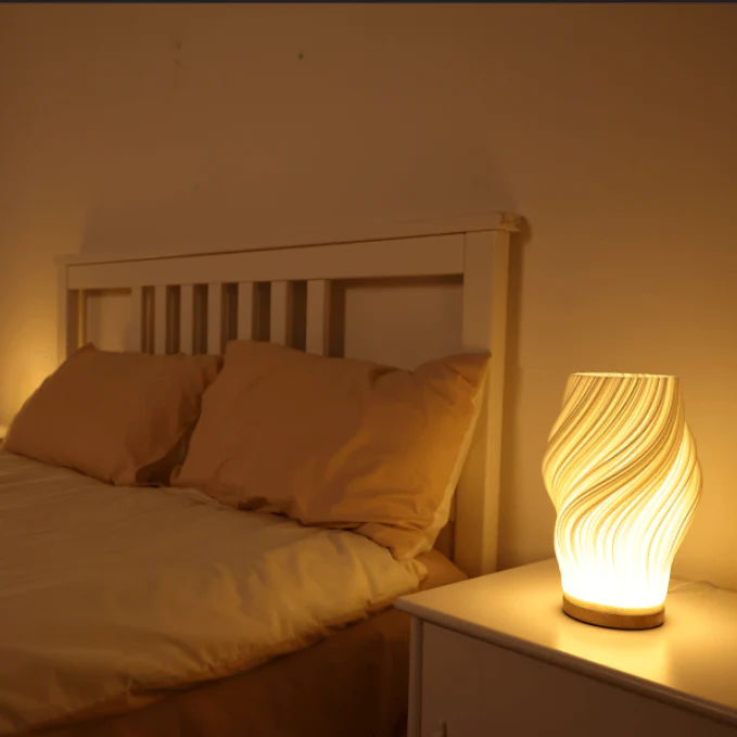 Bedroom scene with a bed and a nightstand lamp emitting warm light.