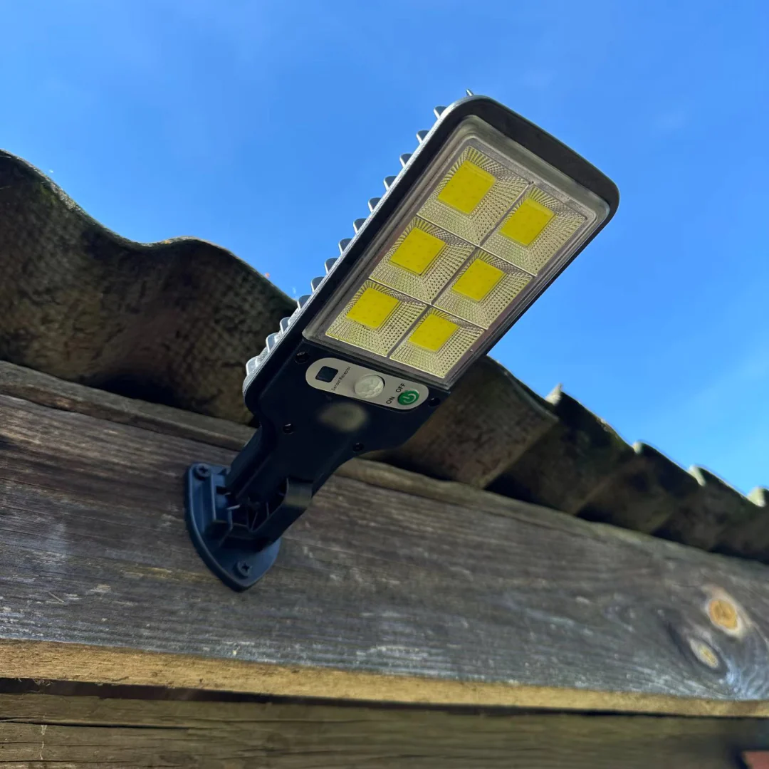 LED flood light on a wooden surface with a clear blue sky background