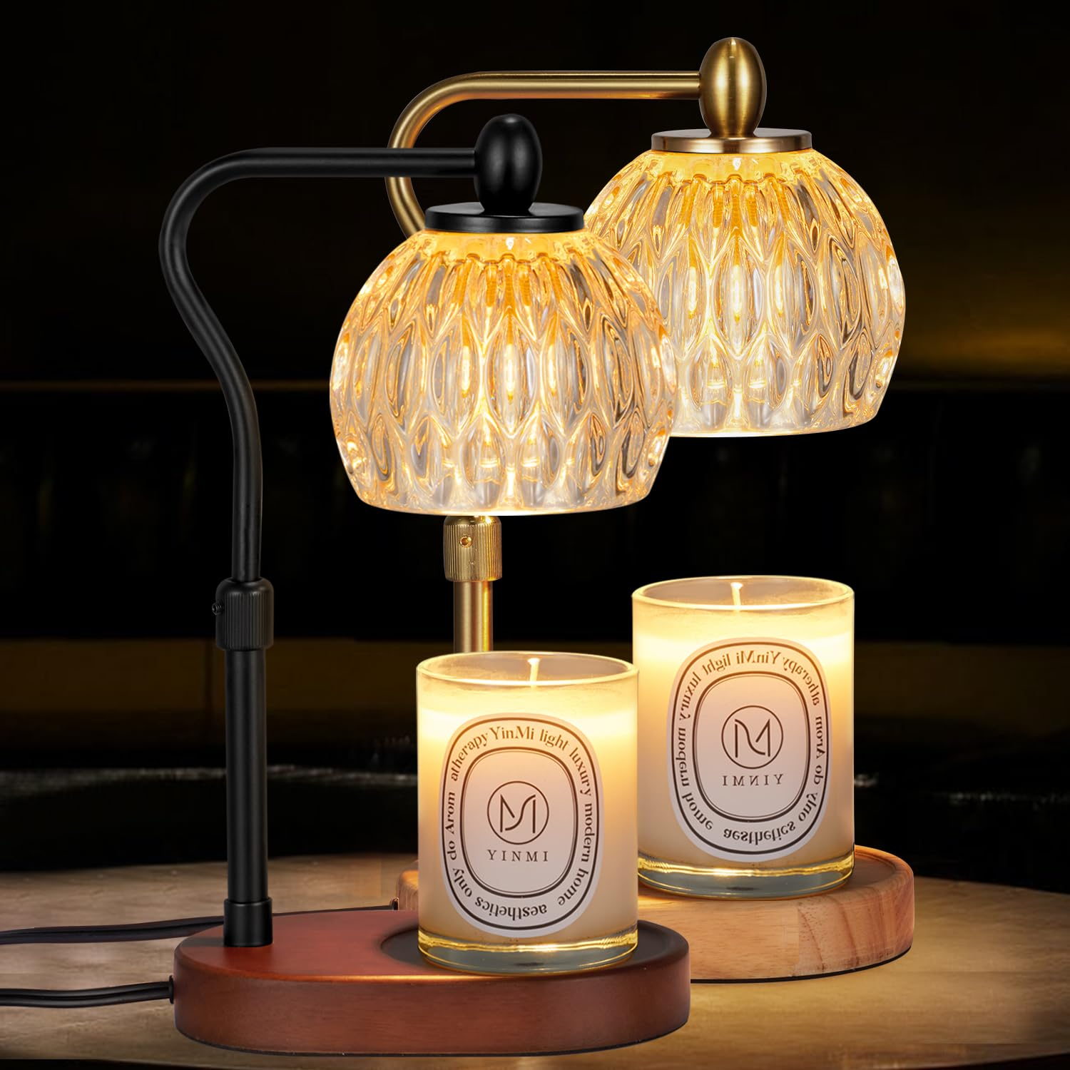 Decorative lamp with glass shades and two candles on a wooden surface.