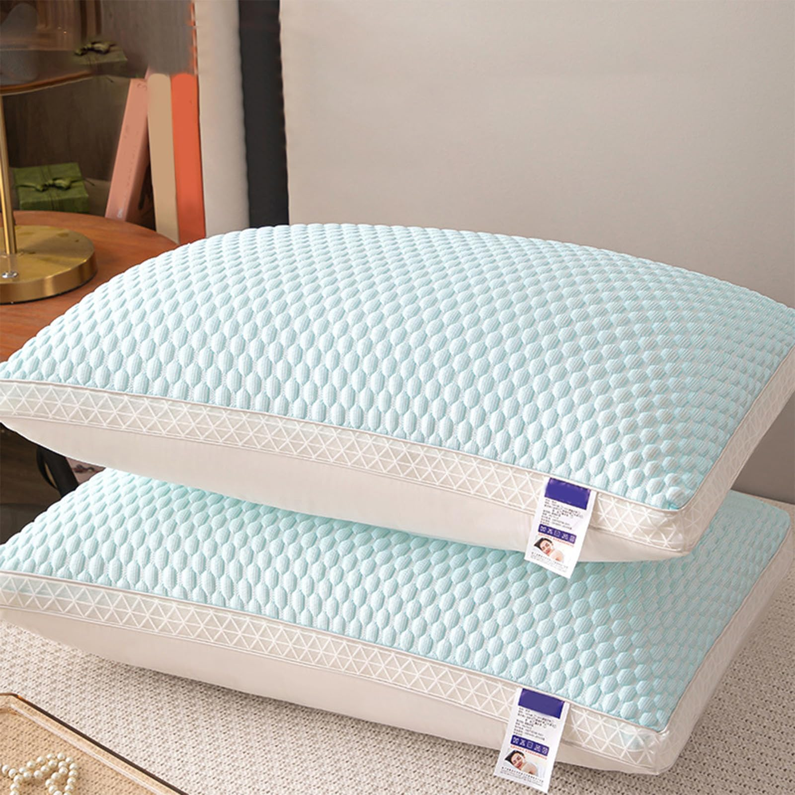 Two light blue pillows with white stitching on a neutral background