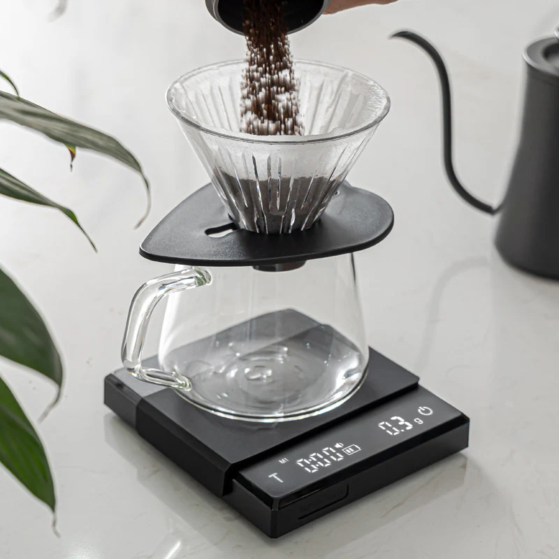 Coffee brewing process with a digital scale measuring coffee grounds.