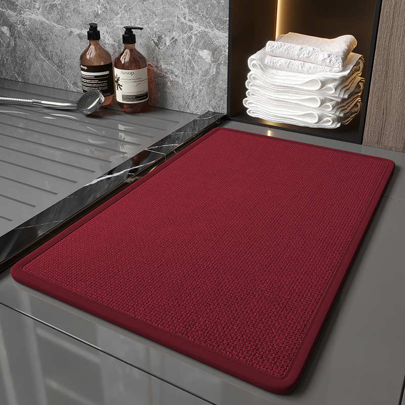 Red mat on a kitchen counter with soap bottles and towels in the background