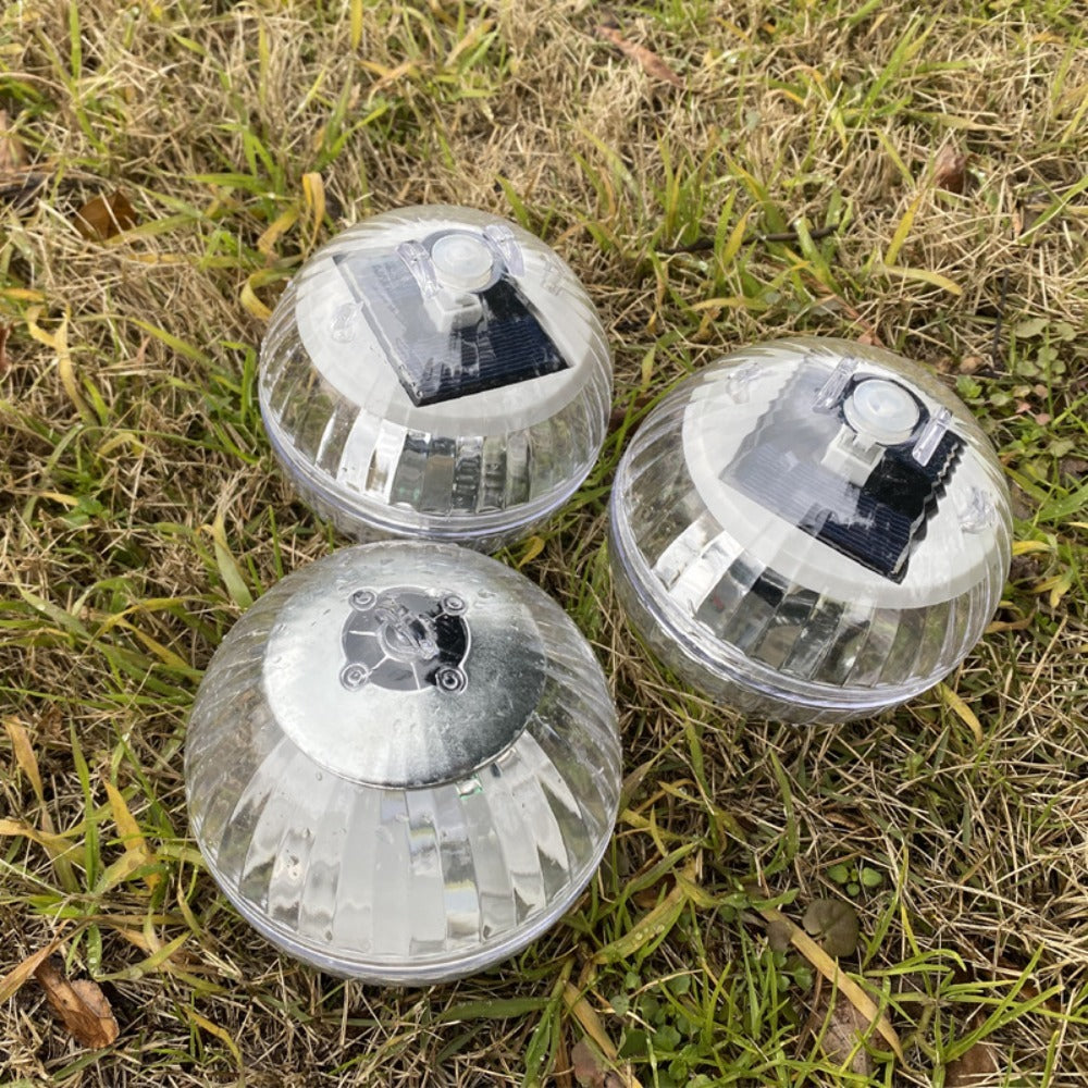 Three solar-powered outdoor lights on grass