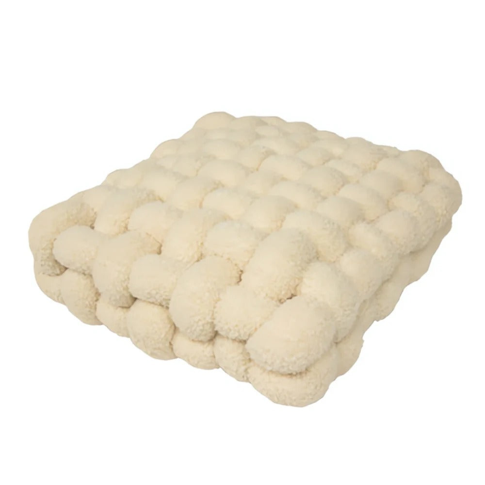 Cream-colored knitted blanket on a white background