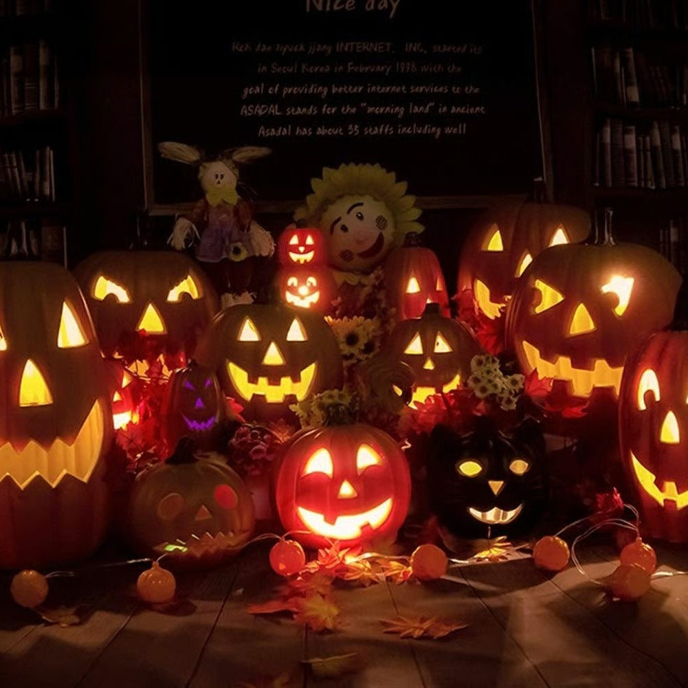 Collection of lit Halloween pumpkins and decorations on a table.