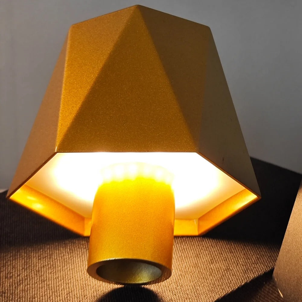 Gold geometric lampshade on a textured surface with a neutral background