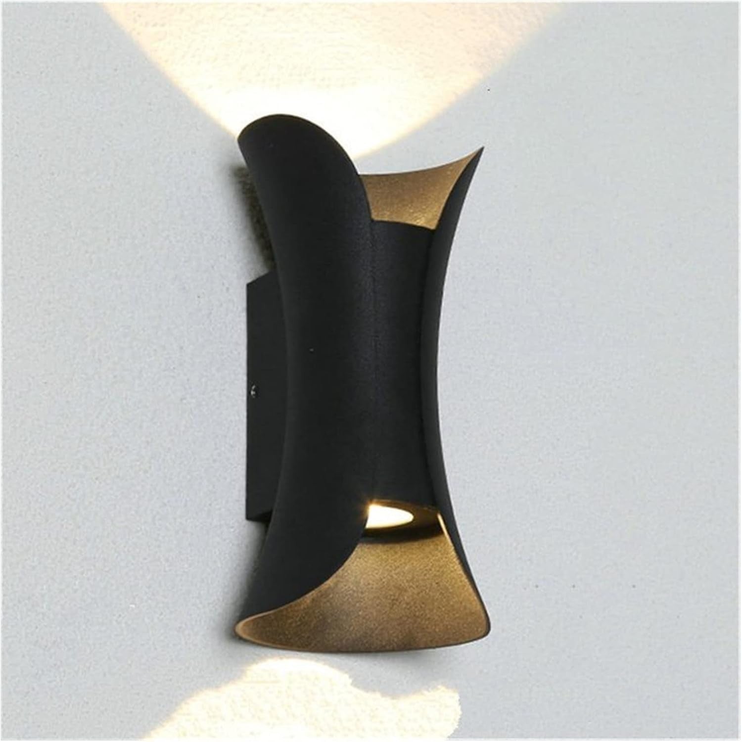 Modern wall-mounted light fixture with black and gold design on a gray background