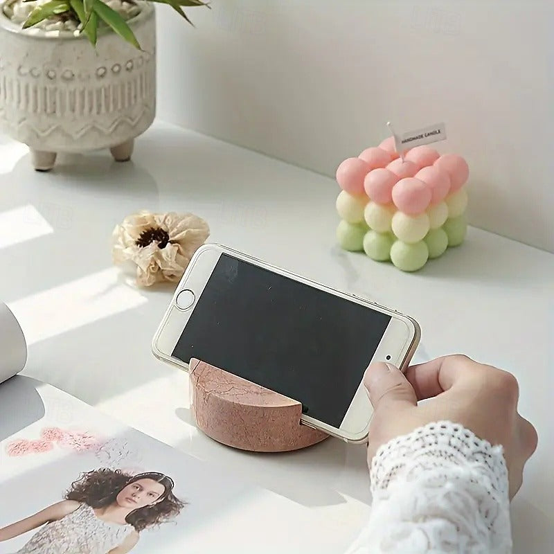 Phone being held on a wooden phone stand with decorative items in the background