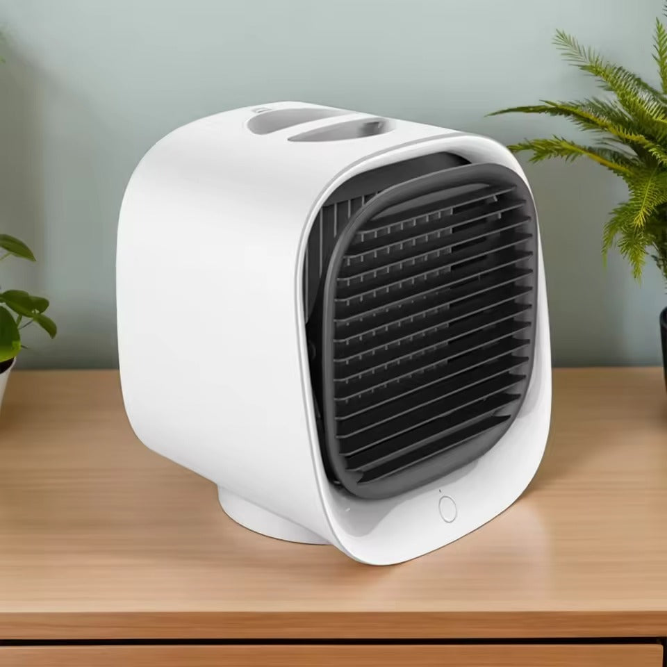 White portable air conditioner on a wooden surface with plants in the background