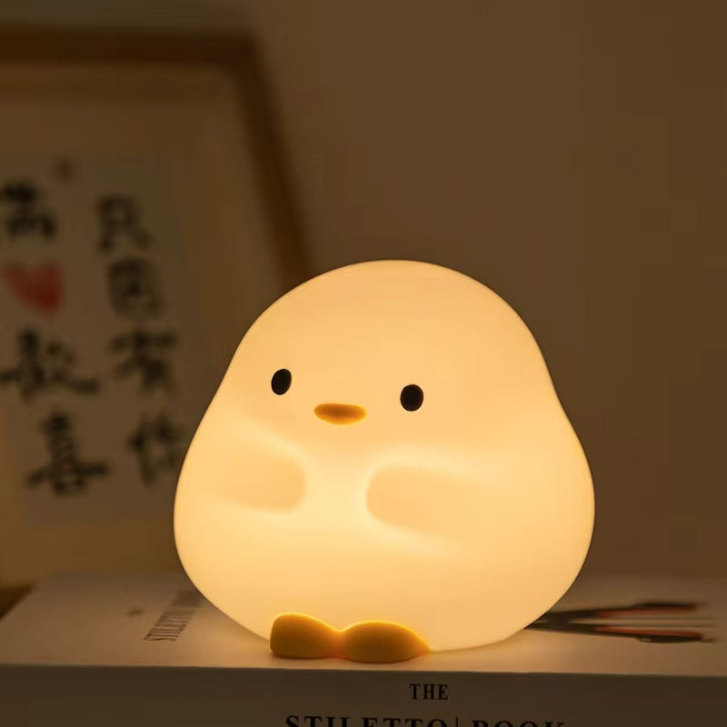 Cute chick-shaped night light on a surface with a blurred background