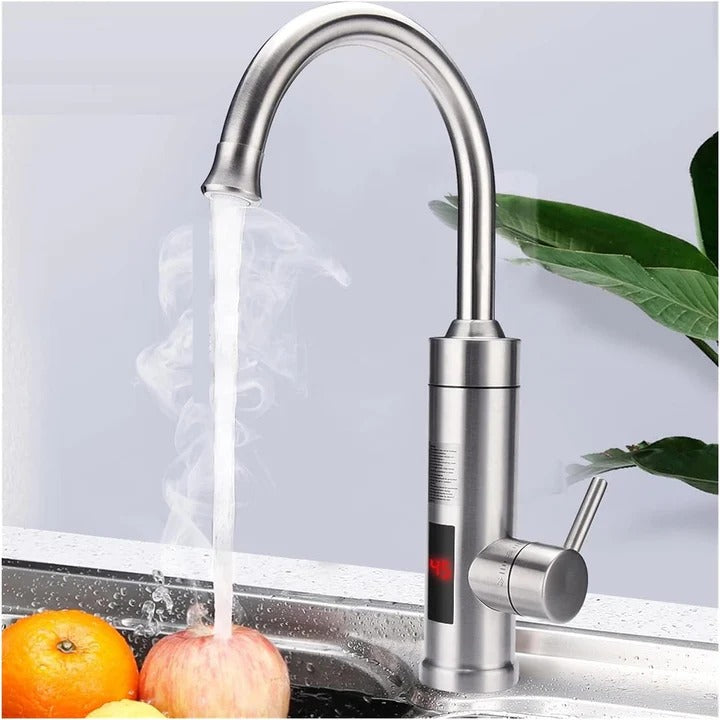 Stainless steel faucet with water flowing into a sink, with fruits and a plant in the background.