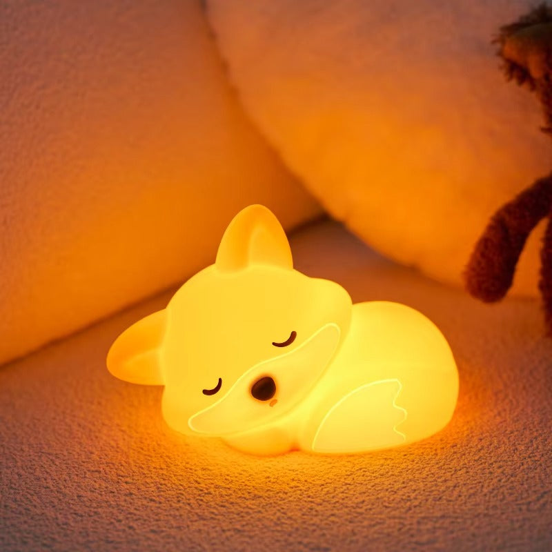 Glowing fox-shaped night light on a soft surface with a blurred background