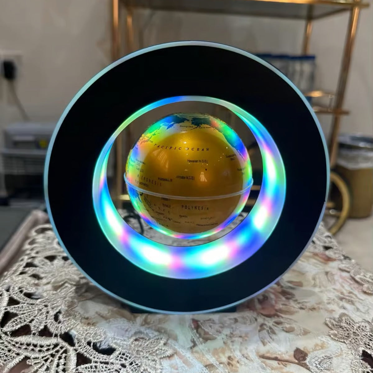 Decorative sphere with colorful light ring on a lace tablecloth