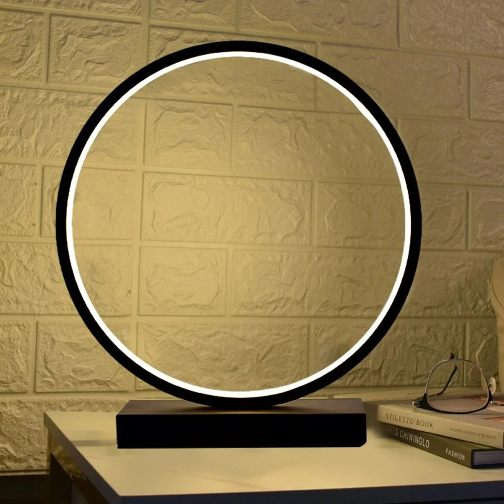 Circular table lamp with a black frame and white LED ring on a textured wall background