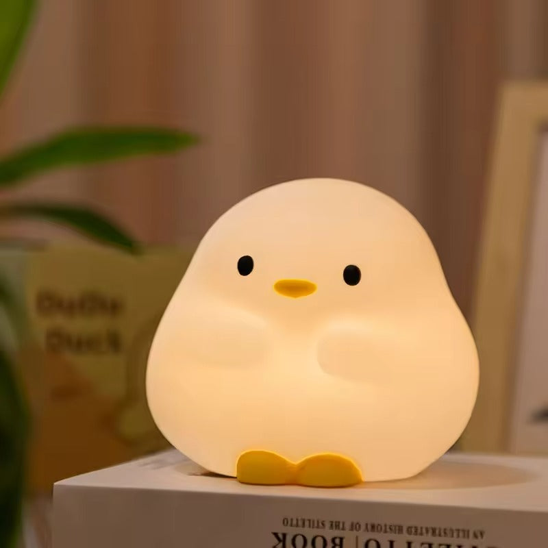 Cute chick-shaped night light on a surface with a blurred background