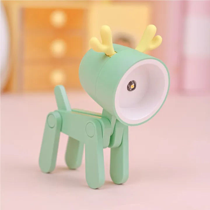 Green toy dog with yellow antlers on a pink background