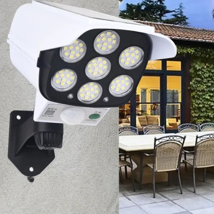 Solar security light attached to a wall with an outdoor patio scene in the background