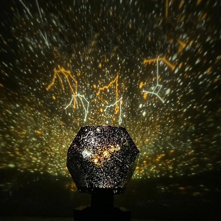 Star projector on a dark background with constellations projected onto the wall.