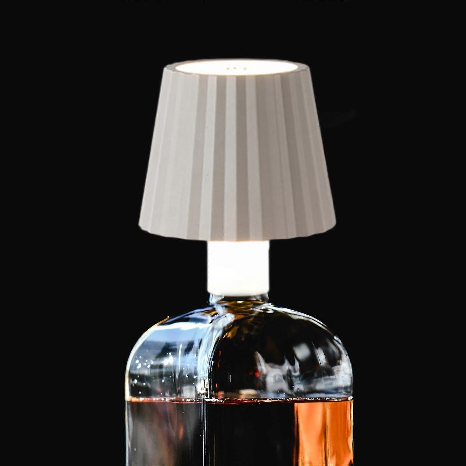 Bottle-shaped lamp with a white lampshade on a black background
