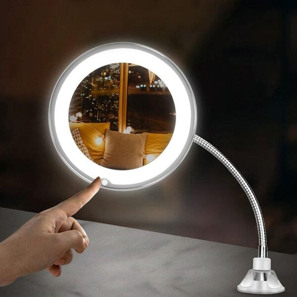 Round light with flexible arm and hand pointing at it on a dark background