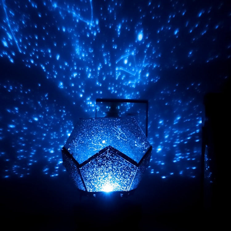 Star projector emitting a blue light against a dark background