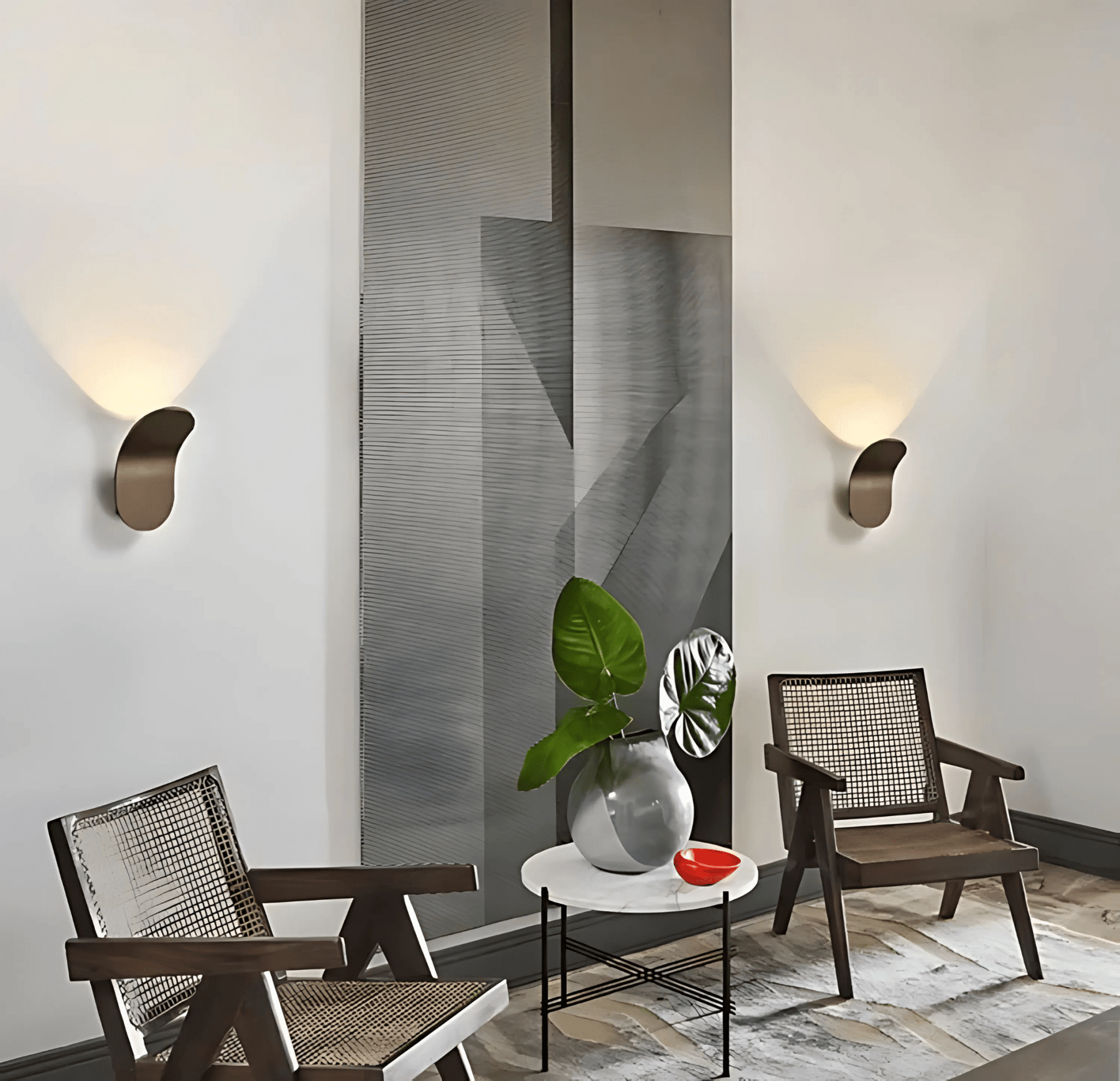 Modern interior with two chairs, a small table, and decorative items against a geometric wall.