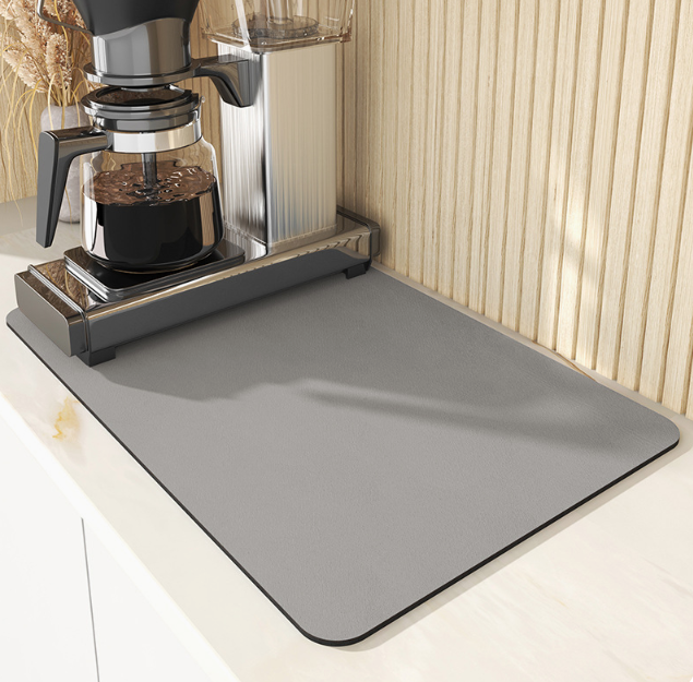 Gray mat on a kitchen counter with a coffee maker in the background