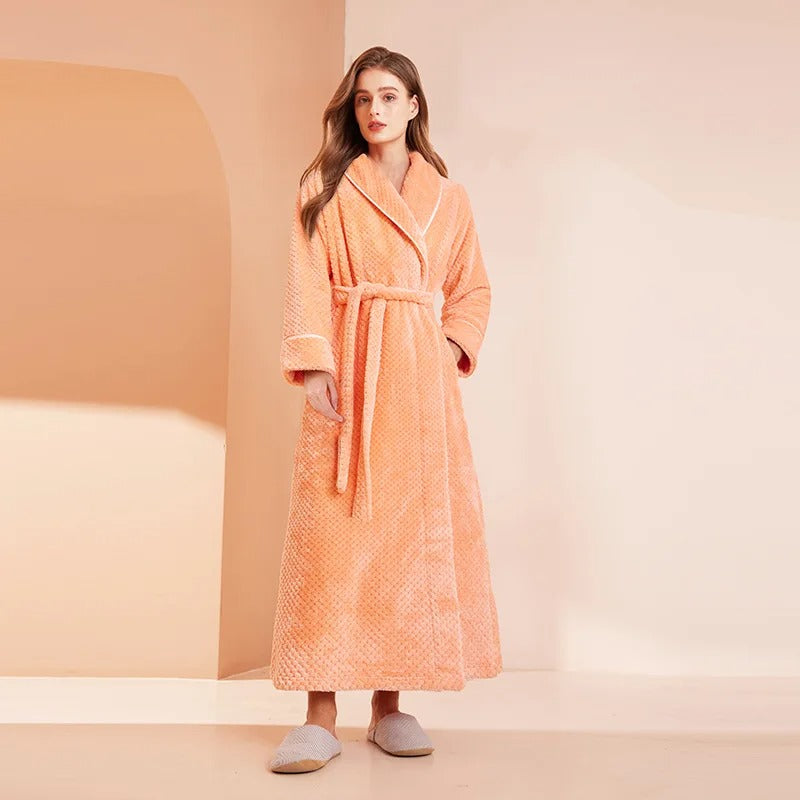 Woman wearing an orange robe against a beige background