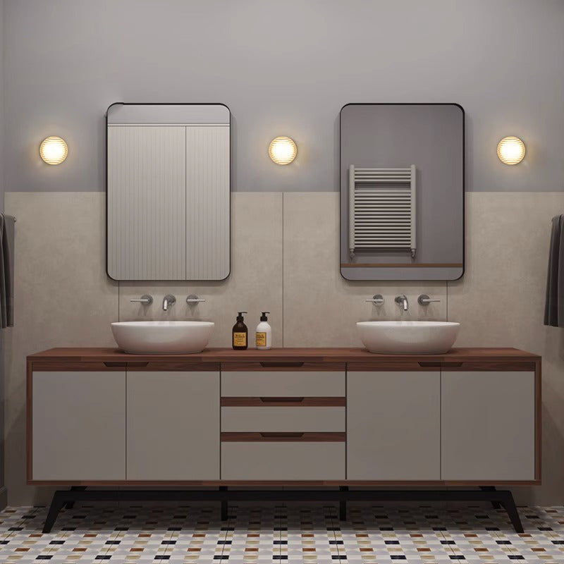 Round wall light fixture on a textured wall on a lavatory area