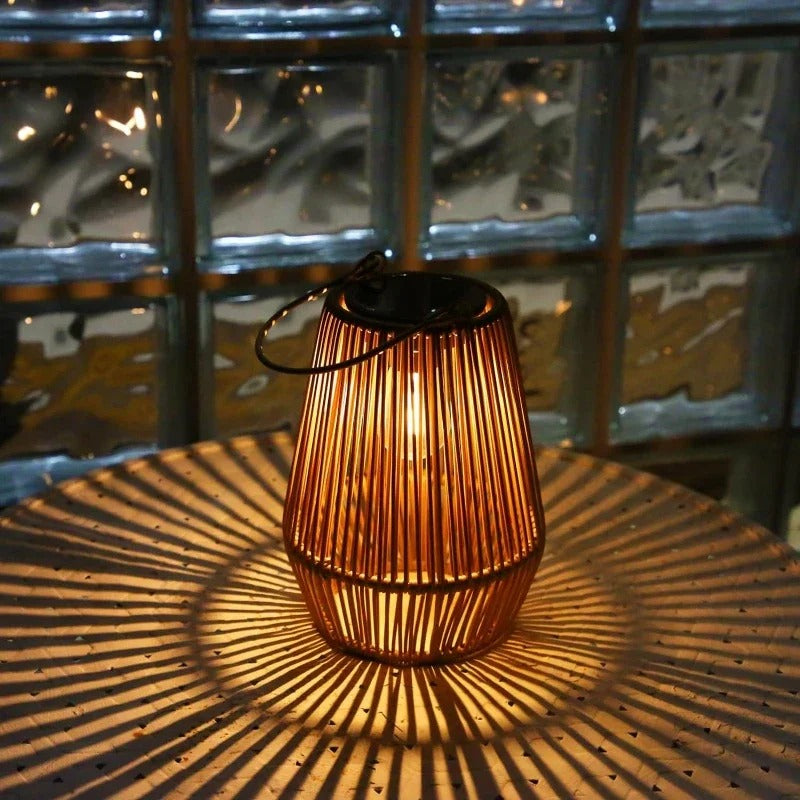 Wicker lantern casting a warm glow on a textured surface with a glass block wall in the background.