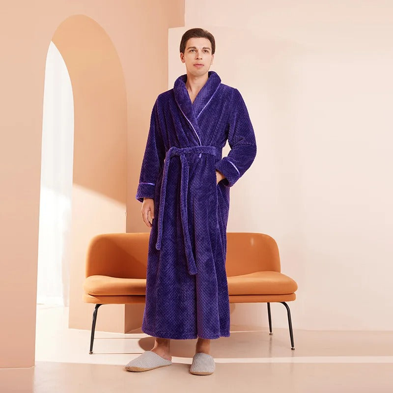 Person wearing a purple robe standing in a room with a brown chair and pink walls.