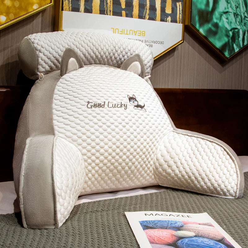 White pillow with 'Good Lucky' text and fox design on a surface with a magazine in the background.