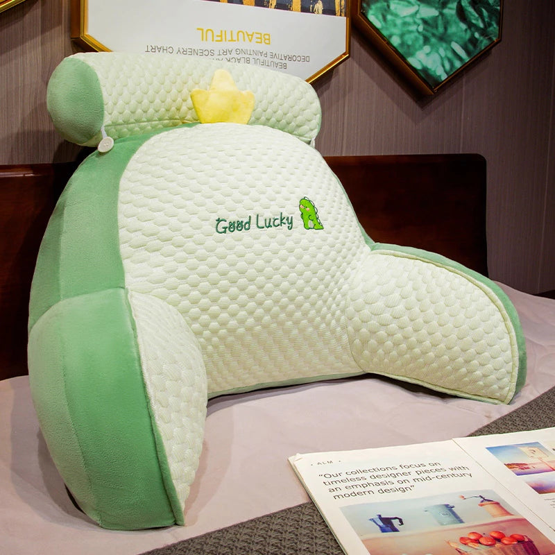 Green and white neck pillow with 'Good Lucky' embroidery on a display table.