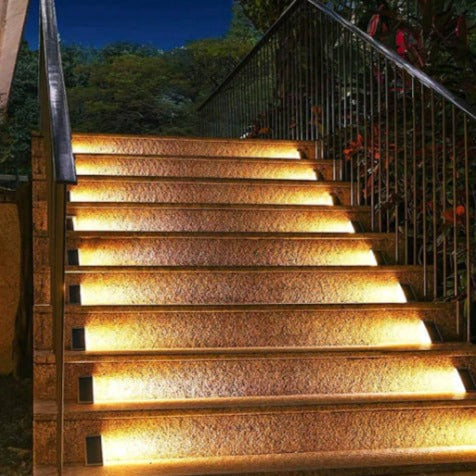 Staircase with embedded lights illuminating the steps at night.