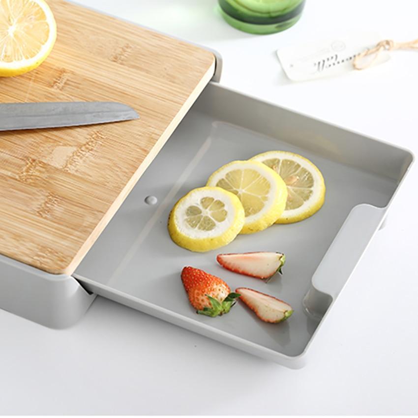 Gray cutting board with sliced lemons and strawberries on a white surface