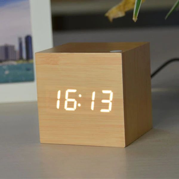 Wooden cube clock with digital display on a surface