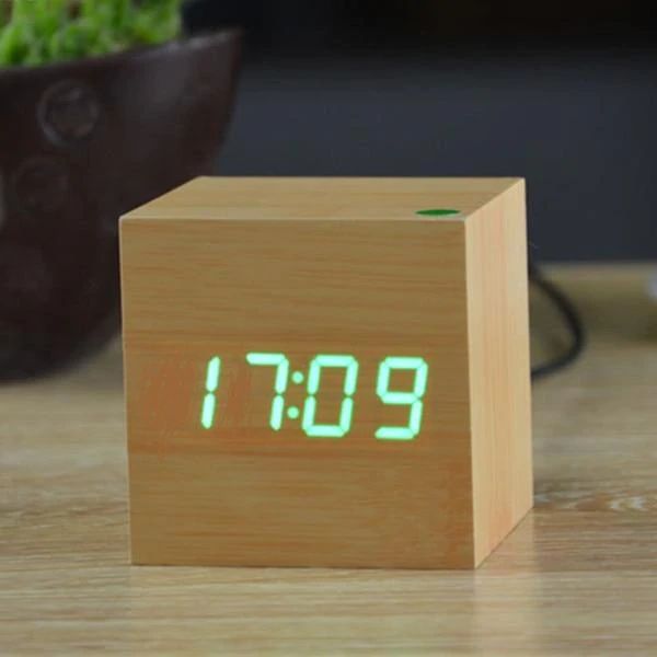 Wooden digital clock with green LED display on a wooden surface