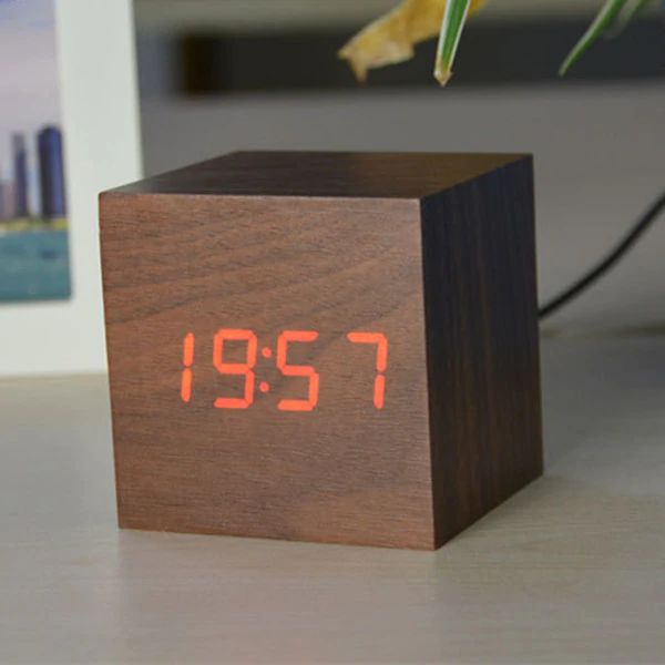 Wooden digital clock with red LED display on a surface