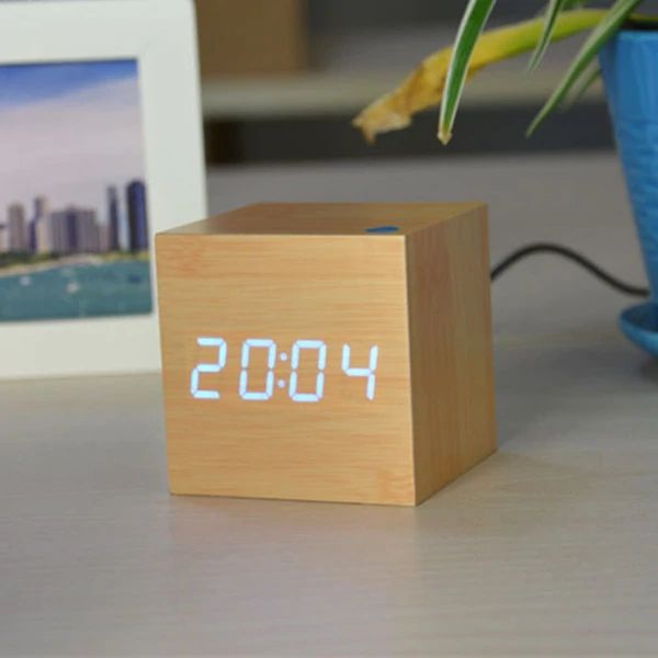 Wooden cube clock with digital time display on a surface