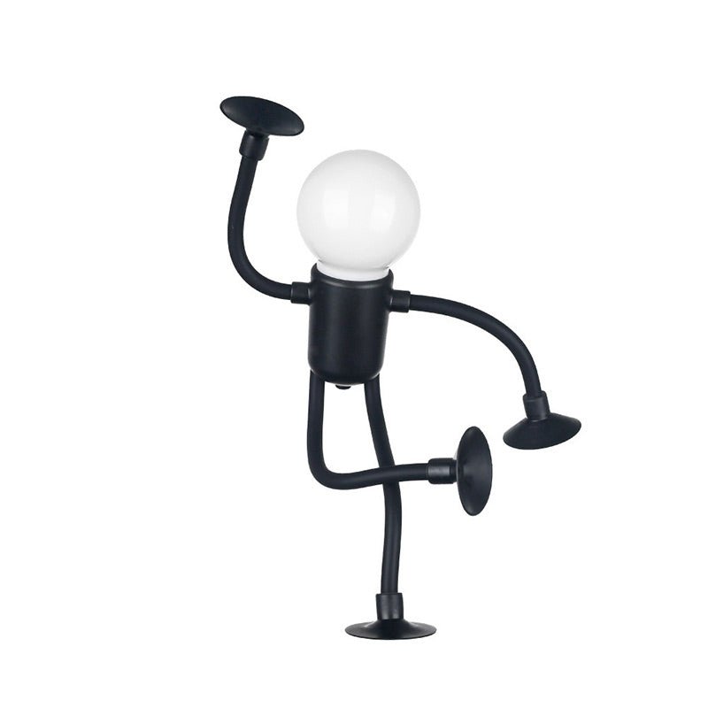 Black metal lamp shaped like a person with a light bulb for a head on a white background