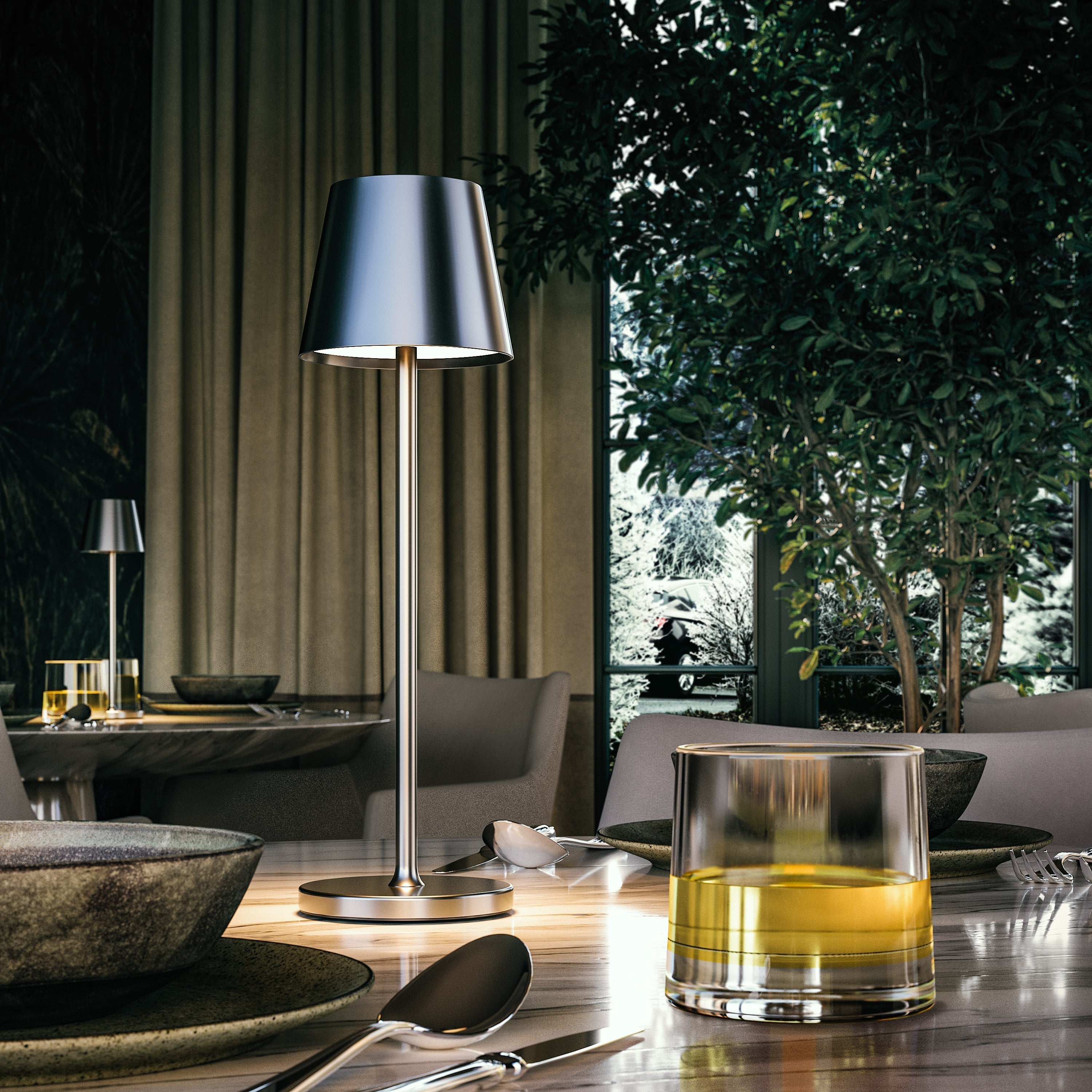 Modern table lamp on a dining table with a glass of yellow liquid in a stylish interior setting.