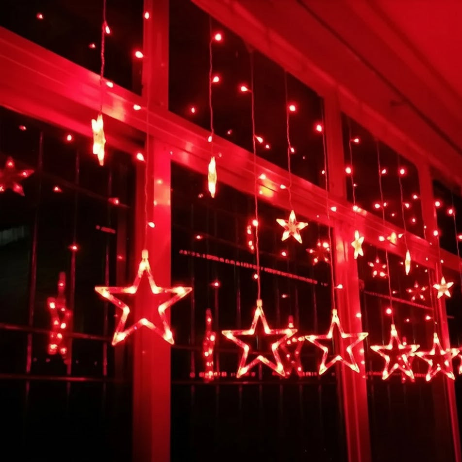 Star-shaped LED lights on a red curtain against a dark background