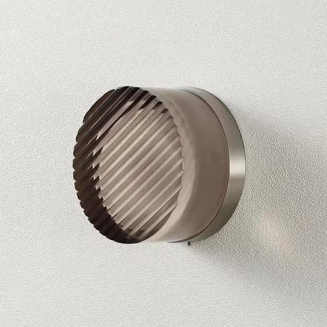 Silver base Round wall light fixture on a textured wall