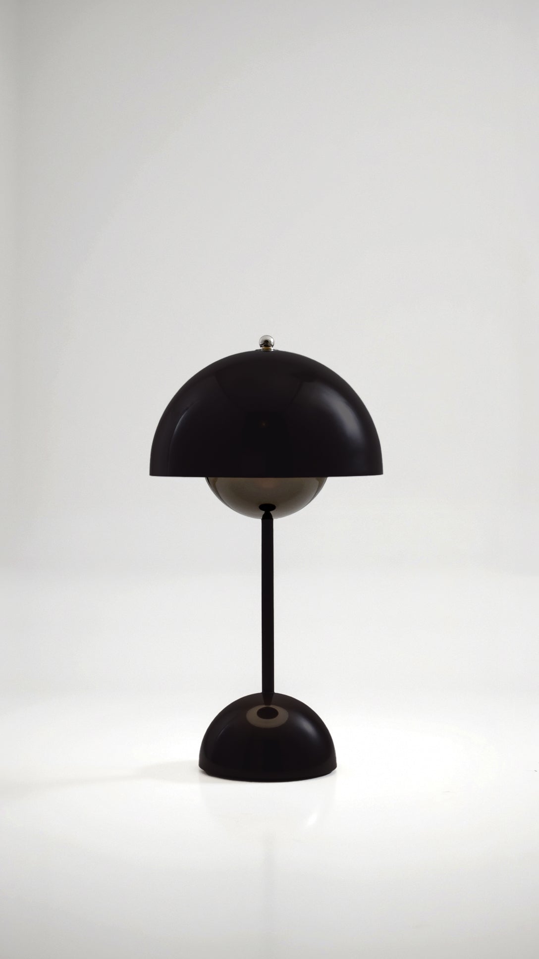 Black table lamp with a white shade on a light gray background