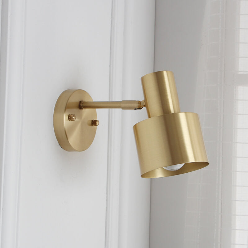 Gold wall-mounted lamp on a white wall