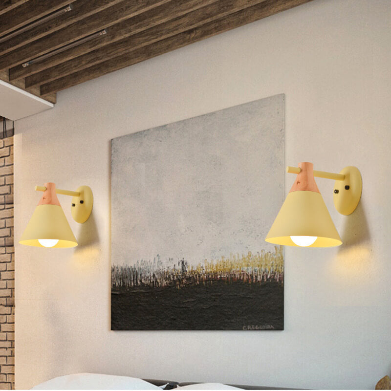 Two wall-mounted lamps with a painting on a white wall.