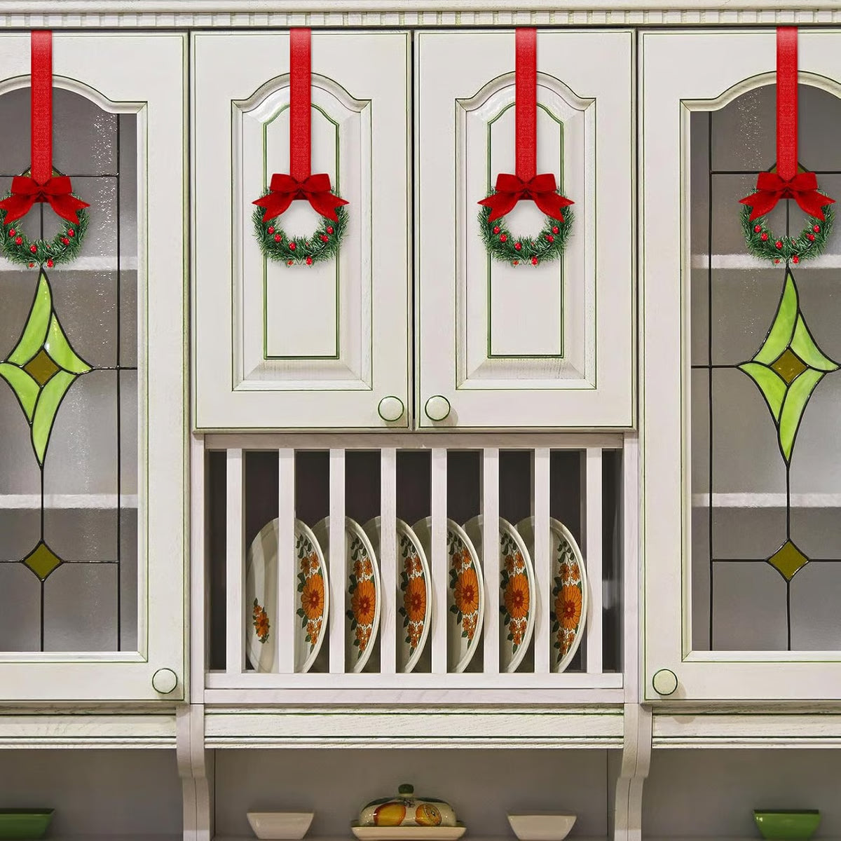 Decorative cabinet with Christmas wreaths and ribbons on glass panels