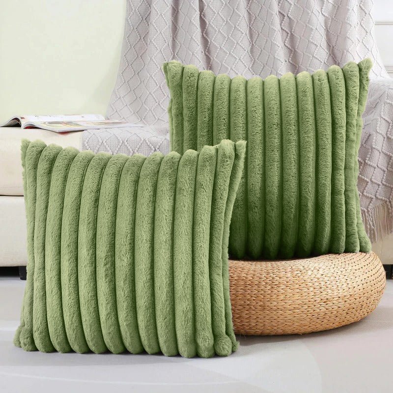 Two green textured pillows on a couch with a neutral background