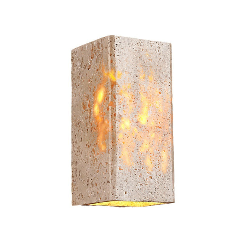 Textured wall sconce with a warm glow on a white background